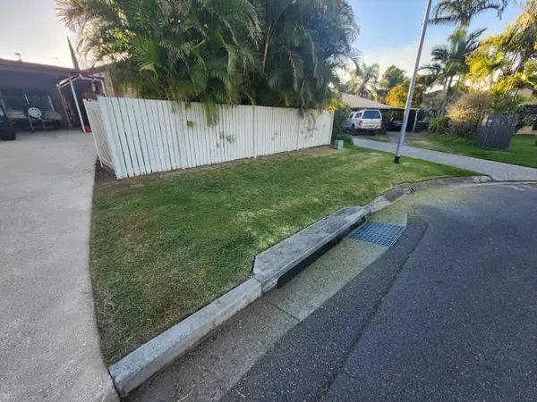 Driveway verge lawn mown with a clean edge along the concrete crossover
