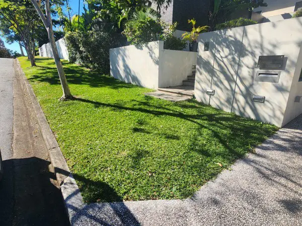Front lawn mown and edged around a rendered wall and letterbox