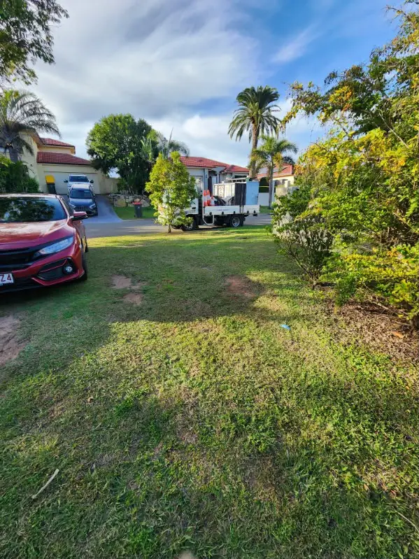 Front yard lawn mown around a driveway and parked car