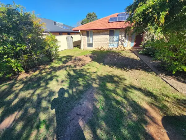 Large front lawn mown clean in front of a brick and tile home